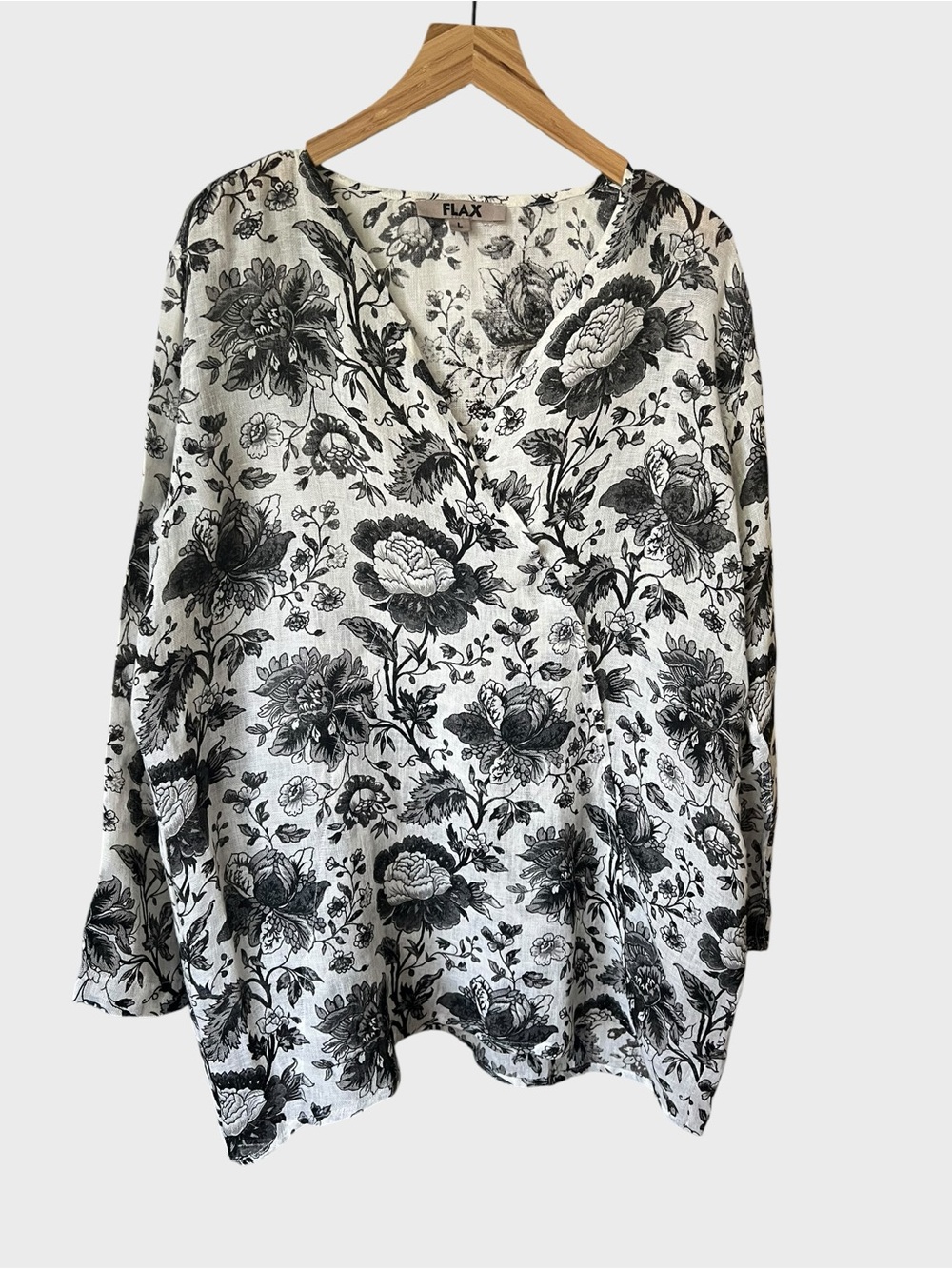 Flax top is crafted from white linen black and white floral print.